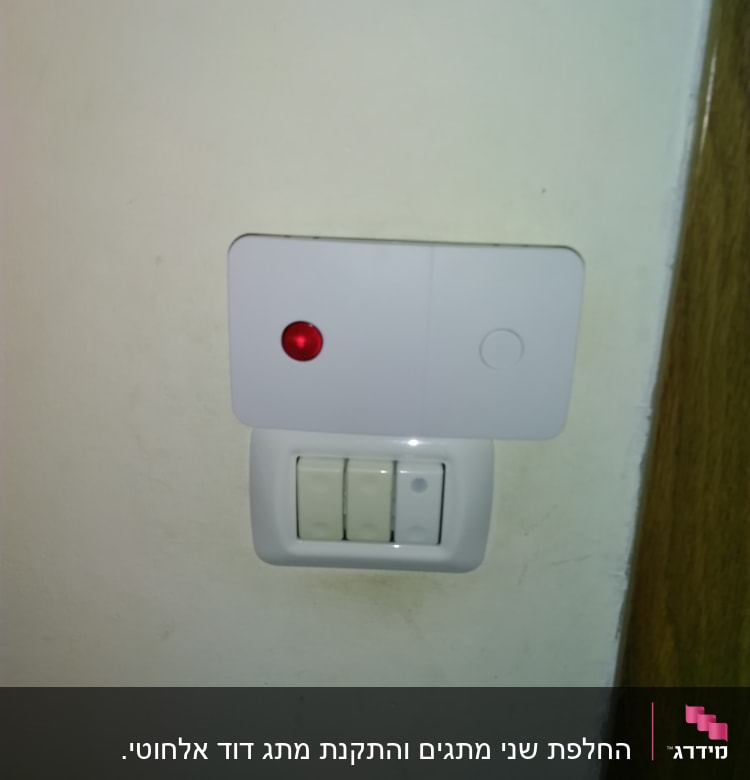 מתגי חשמל עם נורית חיווי אדומה על קיר